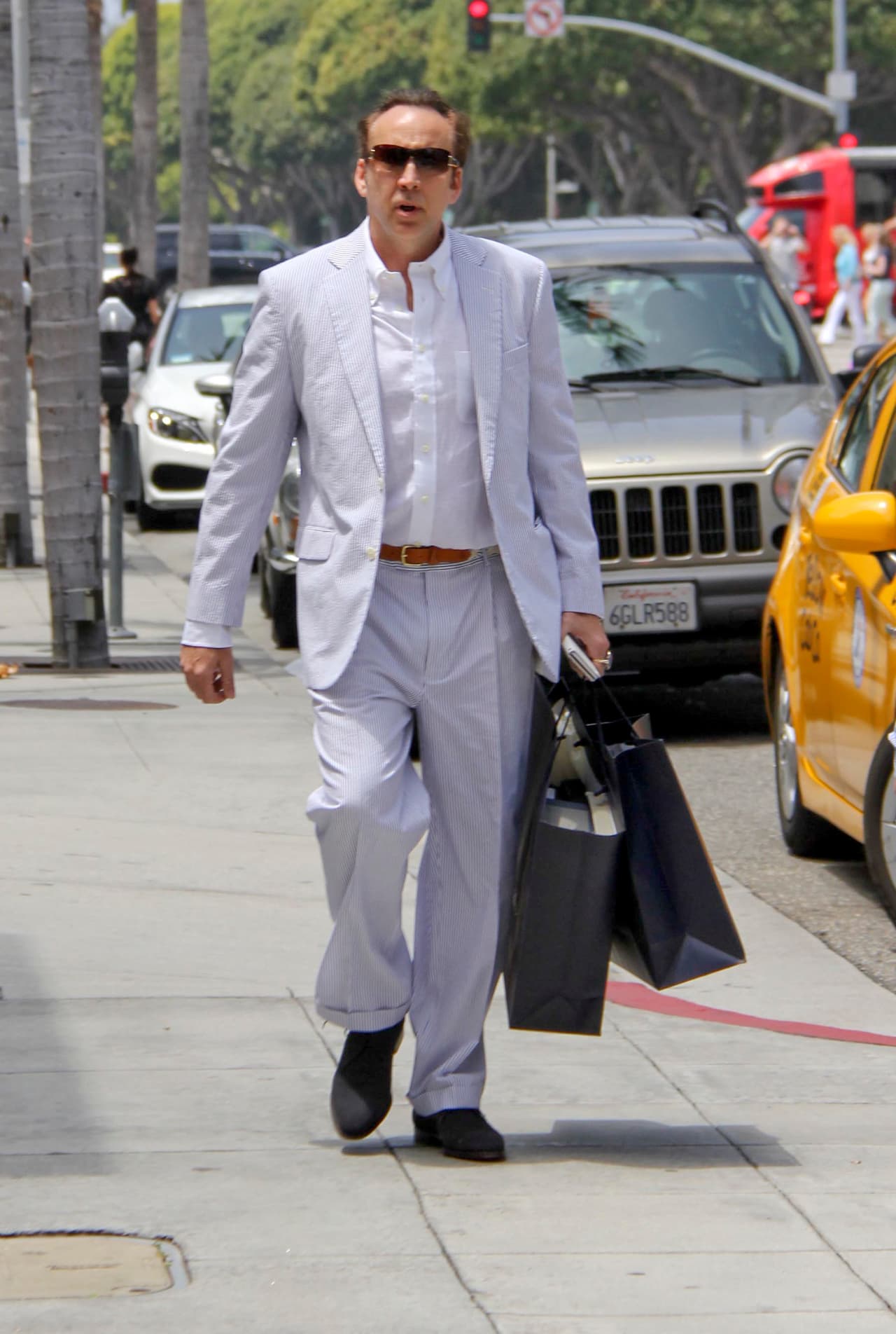 Cage le está enseñando a su hijo la manera correcta de vestir.