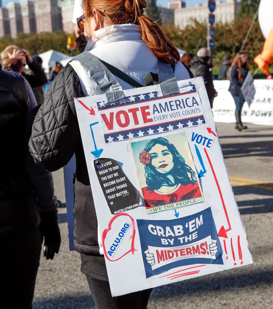 "Vota EEUU: cada voto cuenta". En la pancarta, la manifestante incluye la dirección en internet de la Unión Americana de Libertades Civiles, 
<a href="https://www.aclu.org/">aclu.org.</a>