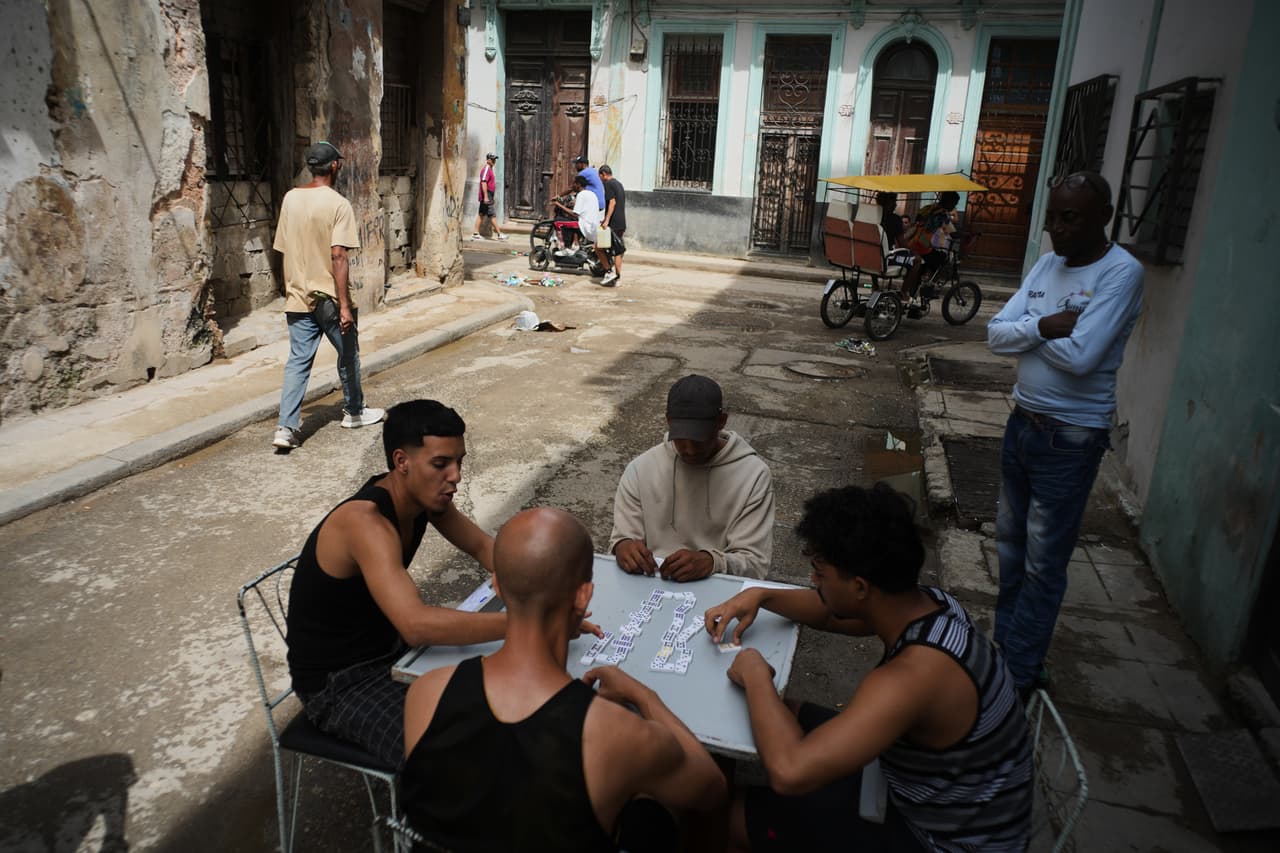Varias personas juegan al dominó al aire libre durante un apagón en La Habana, el martes 17 de marzo de 2026. (Foto AP/Ramon Espinosa)