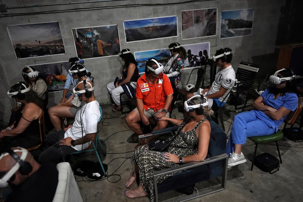 Gente con accesorios de realidad virtual para experimentar el documental "Teleport to Venezuela", de 35 minutos, mientras comienza la promoción nacional y europea del documental en la comunidad venezolana más grande de EEUU en Doral, Florida, el sábado 5 de abril de 2025. (AP Foto/Rebecca Blackwell)