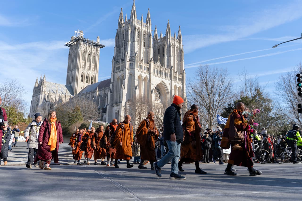 Monjes budistas caminan frente a la Catedral Nacional de Washington después de participar en la Caminata por la Paz, el martes 10 de febrero de 2026, en Washington.