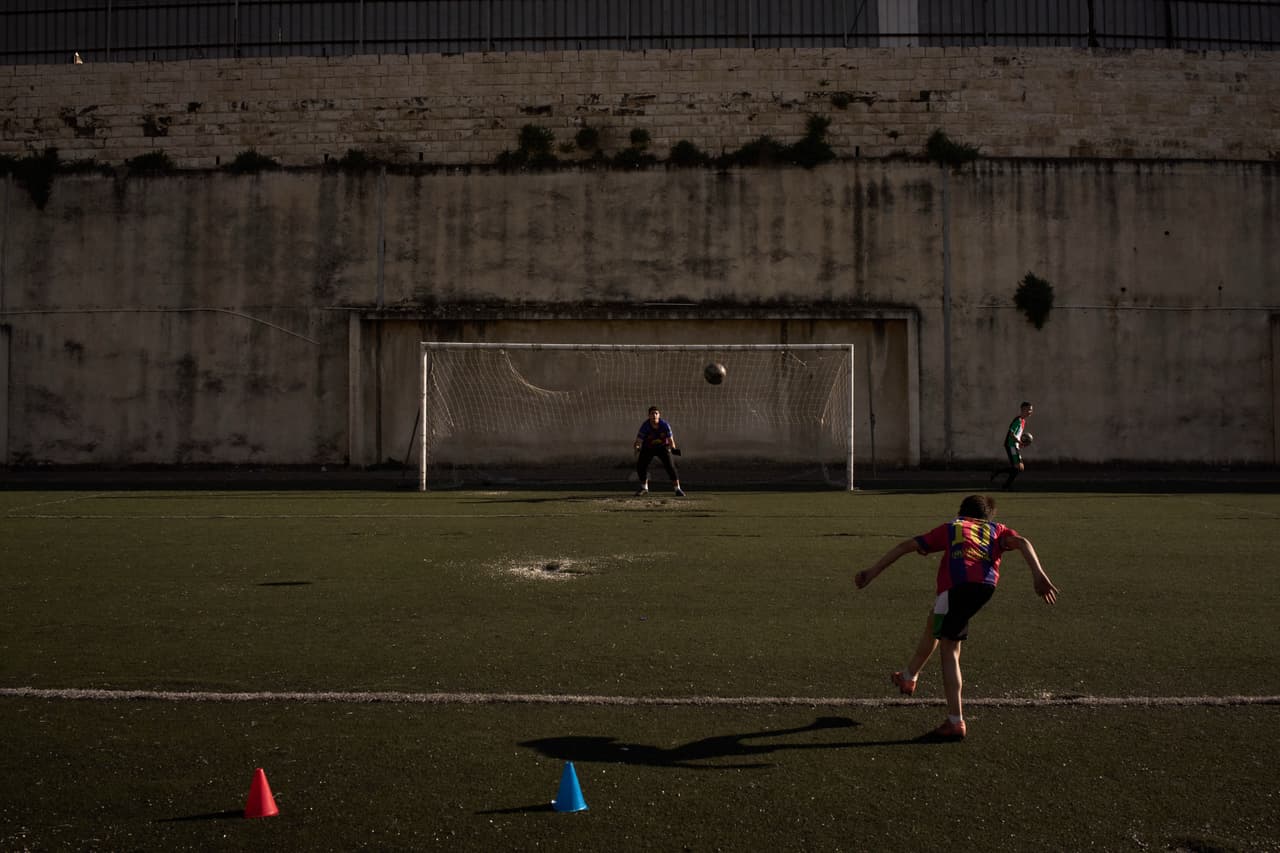 Un niño palestino de una academia de fútbol local, con una camiseta del Barcelona, patea un balón durante una sesión de entrenamiento en el estadio municipal de Nablus, ciudad de Cisjordania, el jueves 7 de mayo de 2026. (Foto AP/Leo Correa)