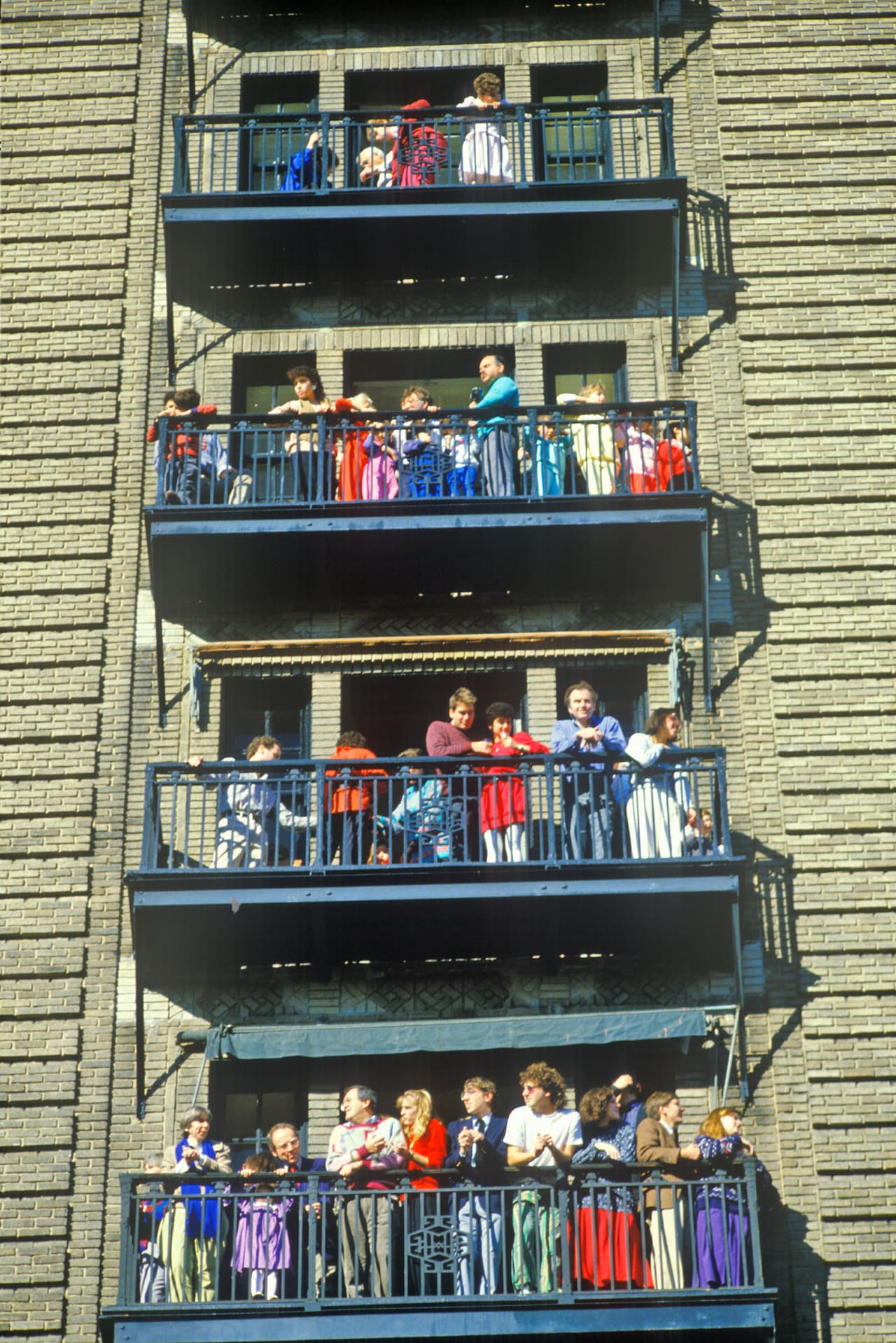 Muchos de los espectadores del desfile los disfrutan desde las ventanas de los departamentos y oficinas de la ciudad. Este año se espera que la parada convoque a más de tres millones de personas. En la fotografía, tomada en 1990, un grupo mira el desfile desde las escaleras de emergencia de un edificio.