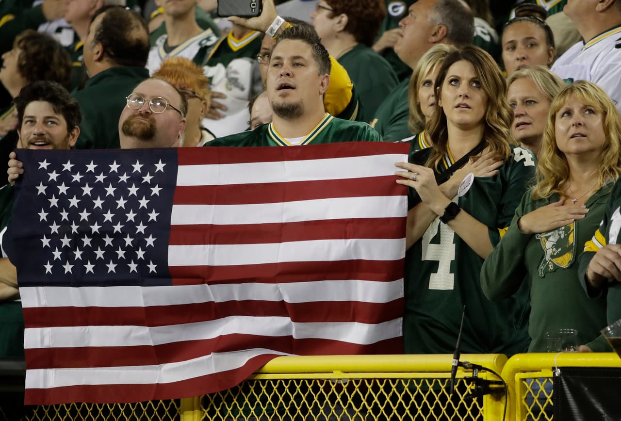 Muchos aficionados aceptaron la petición de Aaron Rodgers y entrelazaron sus brazos mientras sonó el Himno de los Estados Unidos.