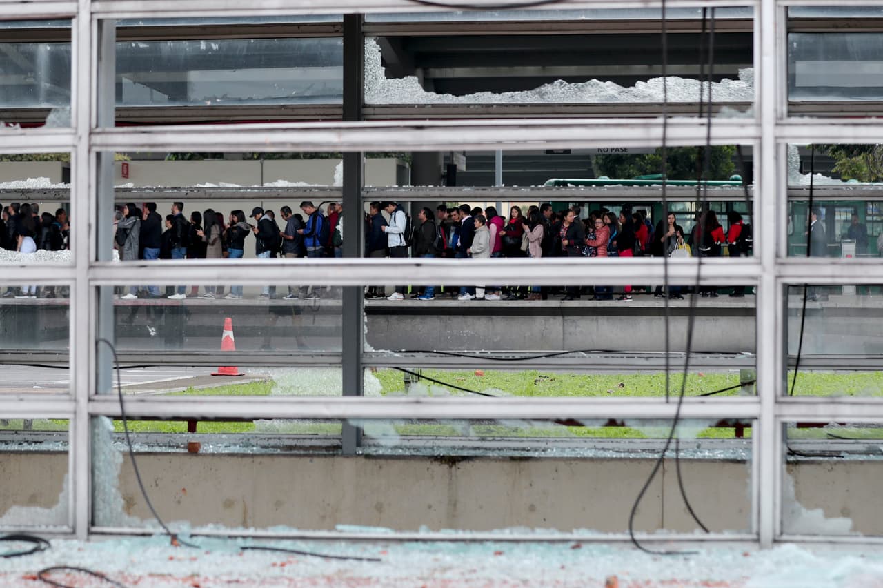 Los pasajeros se alinean en una estación de autobuses dañada por los manifestantes en Bogotá, el viernes 22 de noviembre. Aunque las autoridades reportaron una vuelta a la normalidad en las principales ciudades, en Bogotá continuaban los bloqueos de algunas rutas del sistema de transporte masivo de autobuses.