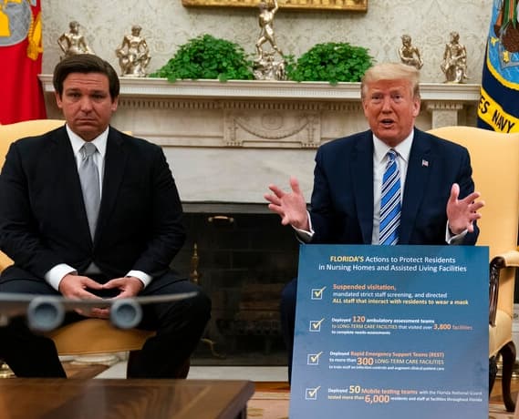 Gov. Ron DeSantis, R-Fla., listens as President Donald Trump talks about the coronavirus response during a meeting in the Oval Office of the White House, Tuesday, April 28, 2020.
