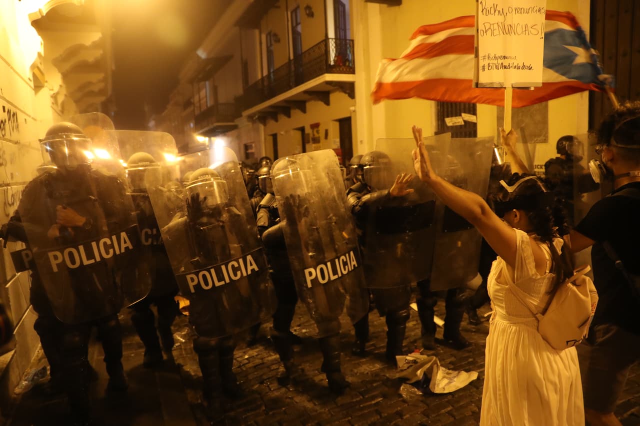 Manifestantes y policías se enfrentan durante una protesta contra Ricardo Rosselló. La policía usó gas lacrimógeno y, según se informa, disparó balas de goma a última hora de la noche del miércoles durante la protesta.