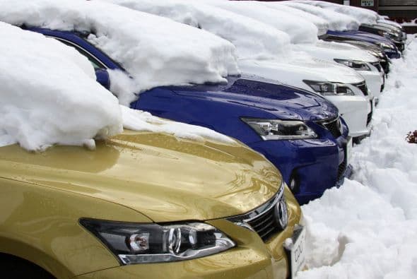 Una venta de automóviles casi sompletamente cubierna de nieve.