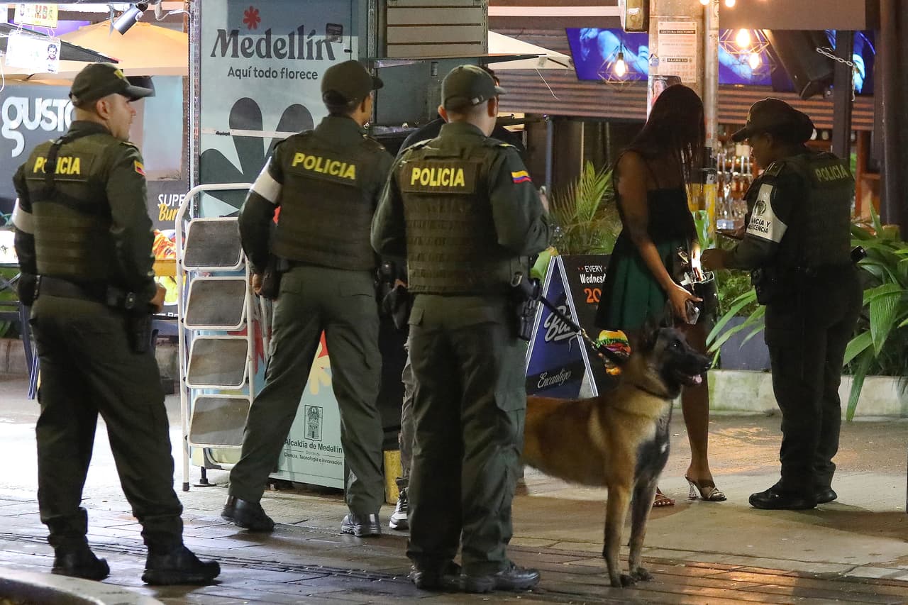 Un policía inspecciona el bolso de una mujer en el parque Lleras de Medellín, Colombia, el 13 de junio de 2024. La ciudad natal de Pablo Escobar, que en su día fue sinónimo de anarquía, se ha convertido en un lugar de moda para turistas.