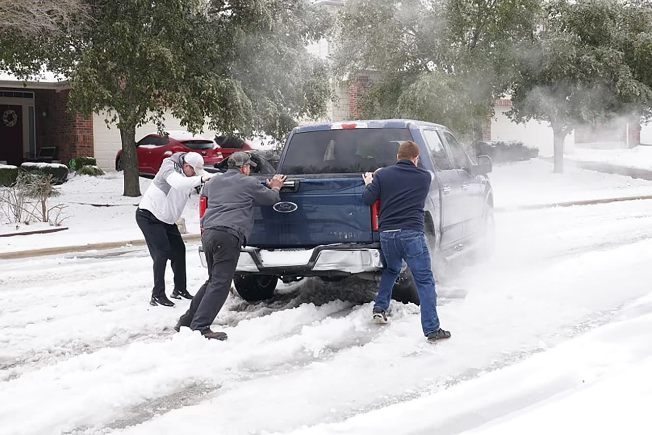 Residentes de Round Rock ayudan al conductor de una camioneta varada en la nieve. Hasta ahora se han registrado cerca de 30 muertes relacionadas con el clima, según las autoridades, la mayoría relacionadas con accidentes de tránsito. 
<br>