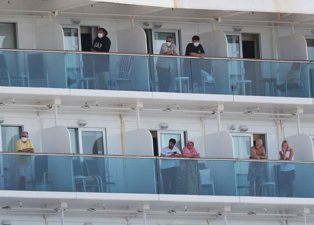 En la imagen, pasajeros del crucero Coral Princess asomados a los balcones el 4 de abril de 2020. Este crucero quedó aislado en Florida después de que varios de sus pasajeros y tripulantes dieron positivo al coronavirus. Fue uno de los tantos cruceros que sufrieron esta situación, antes de que los viajes fueran compleamente cancelados.