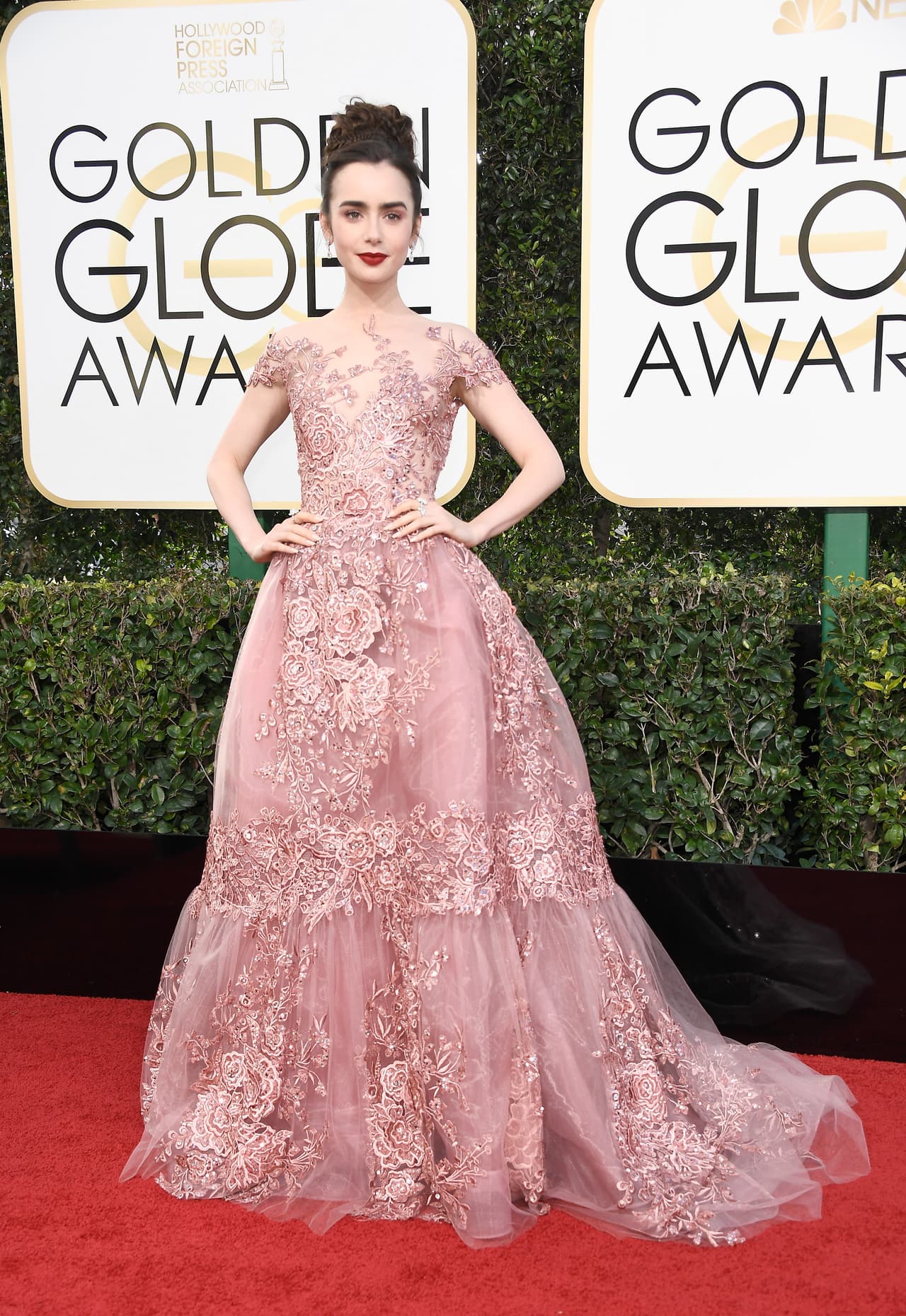 Lily Collins con un vestido rosa empolvado con apliques en forma de rosas metalizadas.