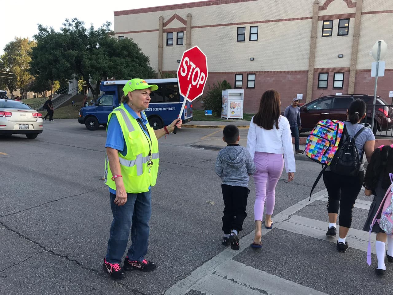 Aquí una escena en la que un trabajador detenía el tránsito con su letrero para ayudar a que los estudiantes y sus padres cruzaran la calle.