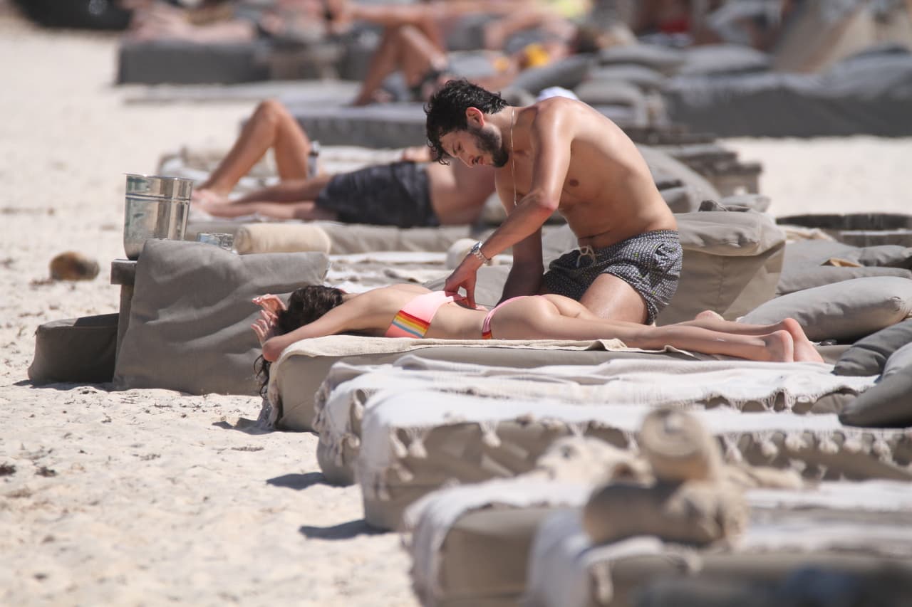 Él se levantó, ella se recostó boca abajo y Sebastián comenzó a ponerle bloqueador.