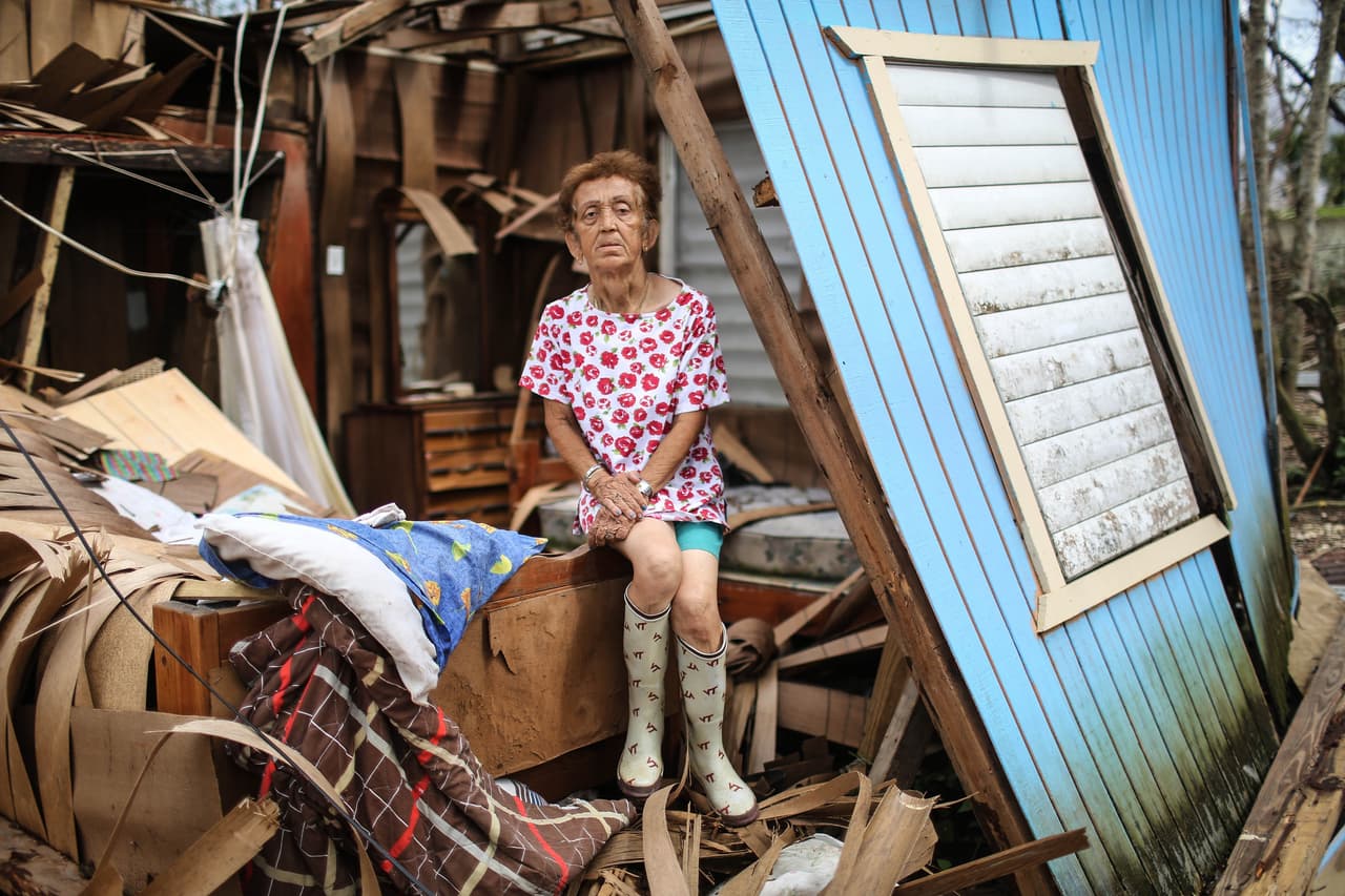 Sonia Torres toma un descanso de la limpieza de su casa destruida, tres semanas después del paso de María. Albonito, Puerto Rico.