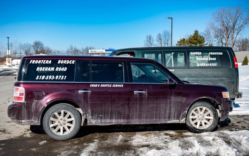 Los taxis están estacionados en la parada de autobús en Plattsburgh, Nueva York, el 3 de marzo de 2023, esperando la llegada de los migrantes para llevarlos al cruce fronterizo de Roxham Road en Champlain, Nueva York.