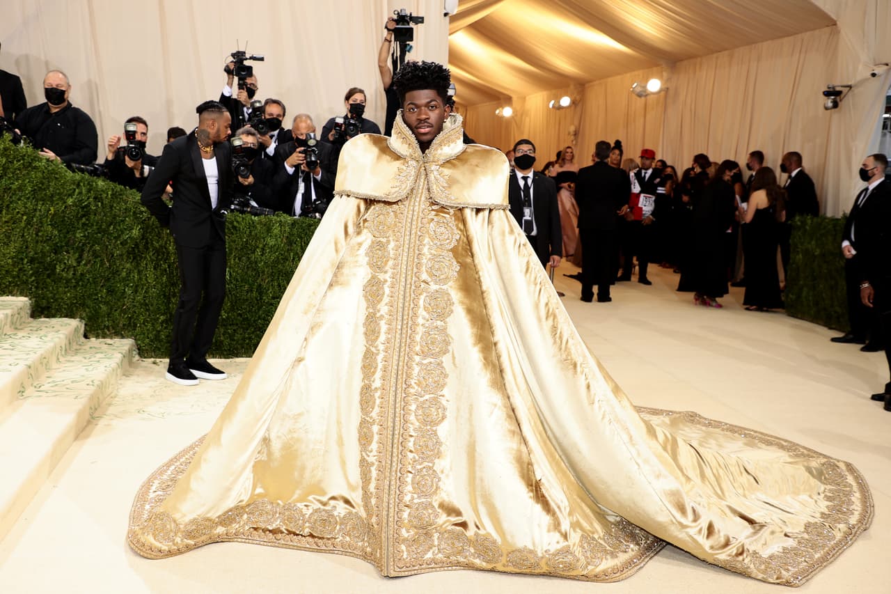 Con un look de lo más versátil, 
<b>Lil Nas X</b> sorprendió en la alfombra blanca de la Met Gala. Una exhuberante capa dorada escondía dos atuendos más.
