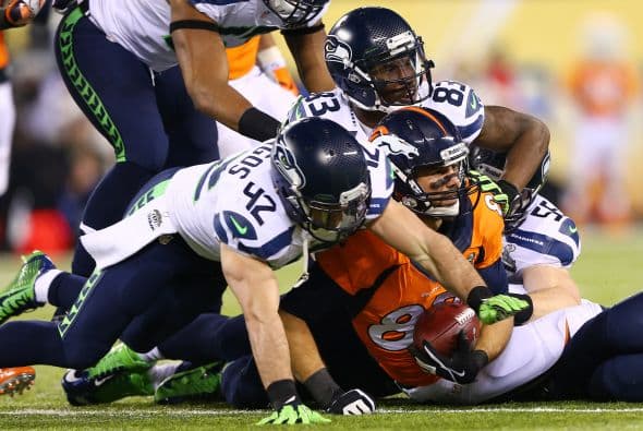 Los Seahawks, con un fútbol "total", el que había trabajado el entrenador del equipo durante toda la temporada regular, el veterano Pete Carroll, derrotaron por paliza de 43-8 a los Broncos, la mejor ofensiva de liga, con el mariscal de campo Peyton Manning a la cabeza. No habían pasado ni 12 segundos desde el comienzo del partido y los Seahawks ya hicieron historia con la anotación más rápida que se había dado jamás en un Super Bowl. Pero lo peor no fue el dejarse anotar dos puntos, sino la imagen de enfrentamiento entre Manning y el centro de origen mexicano Manny Ramírez, que no le dio bien al balón, y aunque el corredor Knowshon Moreno lo recuperó, lo hizo en la zona de protección. La mejor ofensiva de la NFL estaba paralizada, sin saber qué hacer, y ahí fue el comienzo y el final del partido disputado en el MetLife Stadium, de East Rutherford (Nueva Jersey), donde la temperatura fue de 43 grados. Malcom Smith recibió el premio de Jugador Más Valioso (MVP), el octavo defensor que lo consigue en un partido de Super Bowl y el tercer apoyador. Carroll, de 61 años, el tercer entrenador con más edad de la NFL que ganó un Super Bowl, se convirtió en el tercer entrenador que logra los dos títulos de campeón universitario de la NCAA con el equipo de USC y ahora los Seahawks en la NFL.