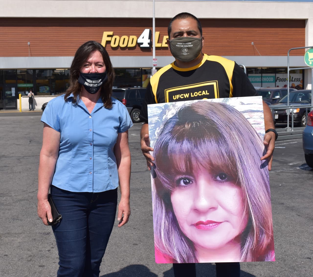 Dos empleados de supermercados sostienen la foto de Ángela Pérez en una manifestación.