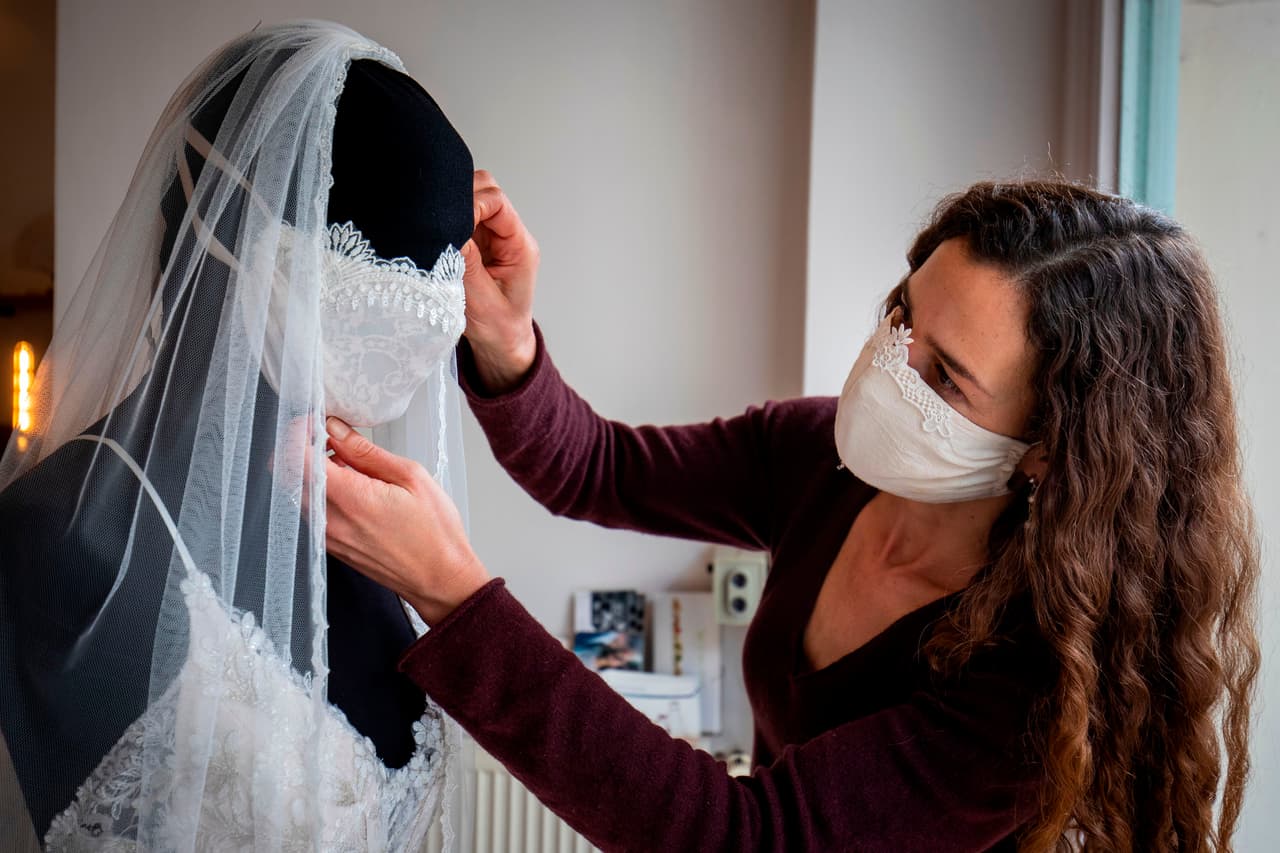 La diseñadora de moda alemana Friederike Jorzig ajusta la máscara de uno de sus nuevos vestidos de novia, en su tienda de Berlín. 31 de marzo.