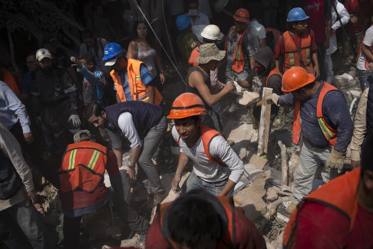 Voluntarios ayudan a remover escombros de un edificio que colapsó en Ciudad de México. El Servicio Sismológico Nacional informó que el sismo ocurrió a las 01:14 pm, tiempo del Centro de México.