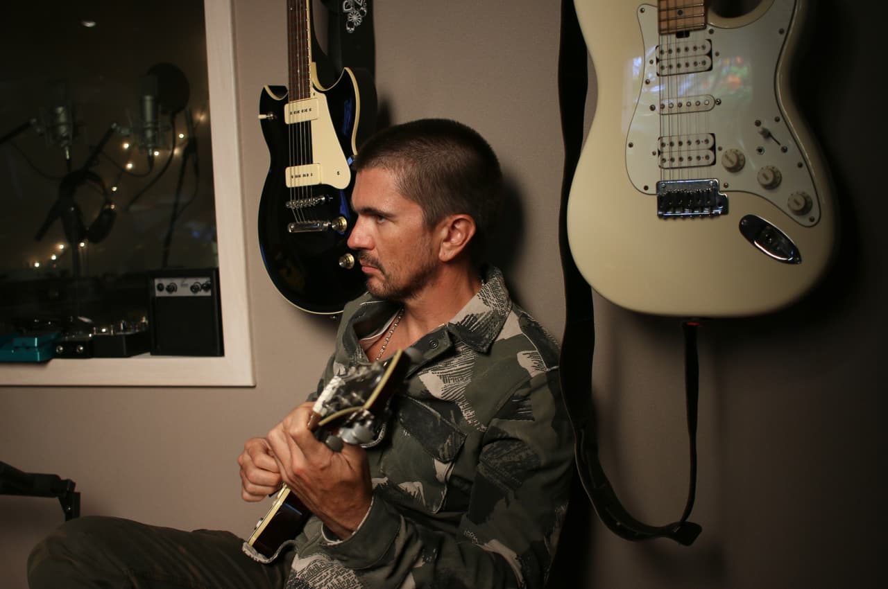 Mientras observa a Sky y Mosty trabajar, Juanes no puede evitar tocar la guitarra.