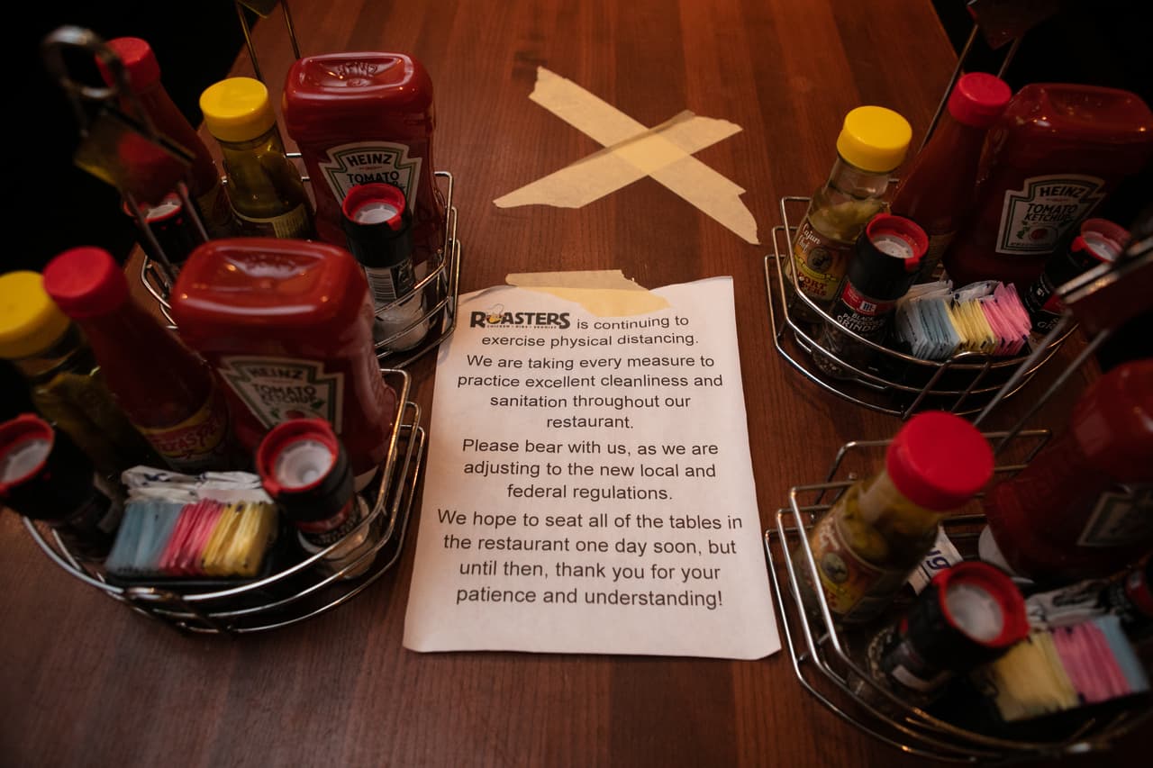 La señalización explica por qué algunas mesas están cerradas en Roasters el 27 de abril de 2020 en Atlanta, Georgia. Roasters está abierto para servicio de comedor con protocolos de distanciamiento social y saneamiento.