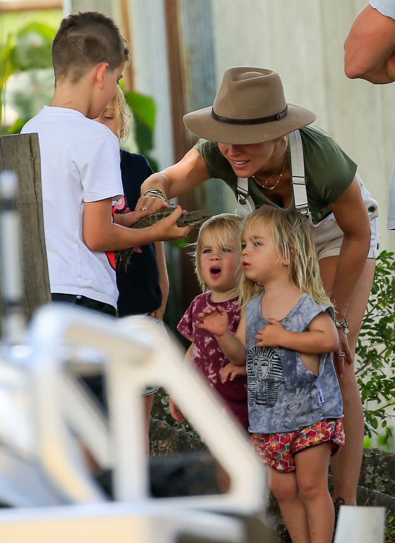Los gemelitos viendo la lagartija que encontró el chico.