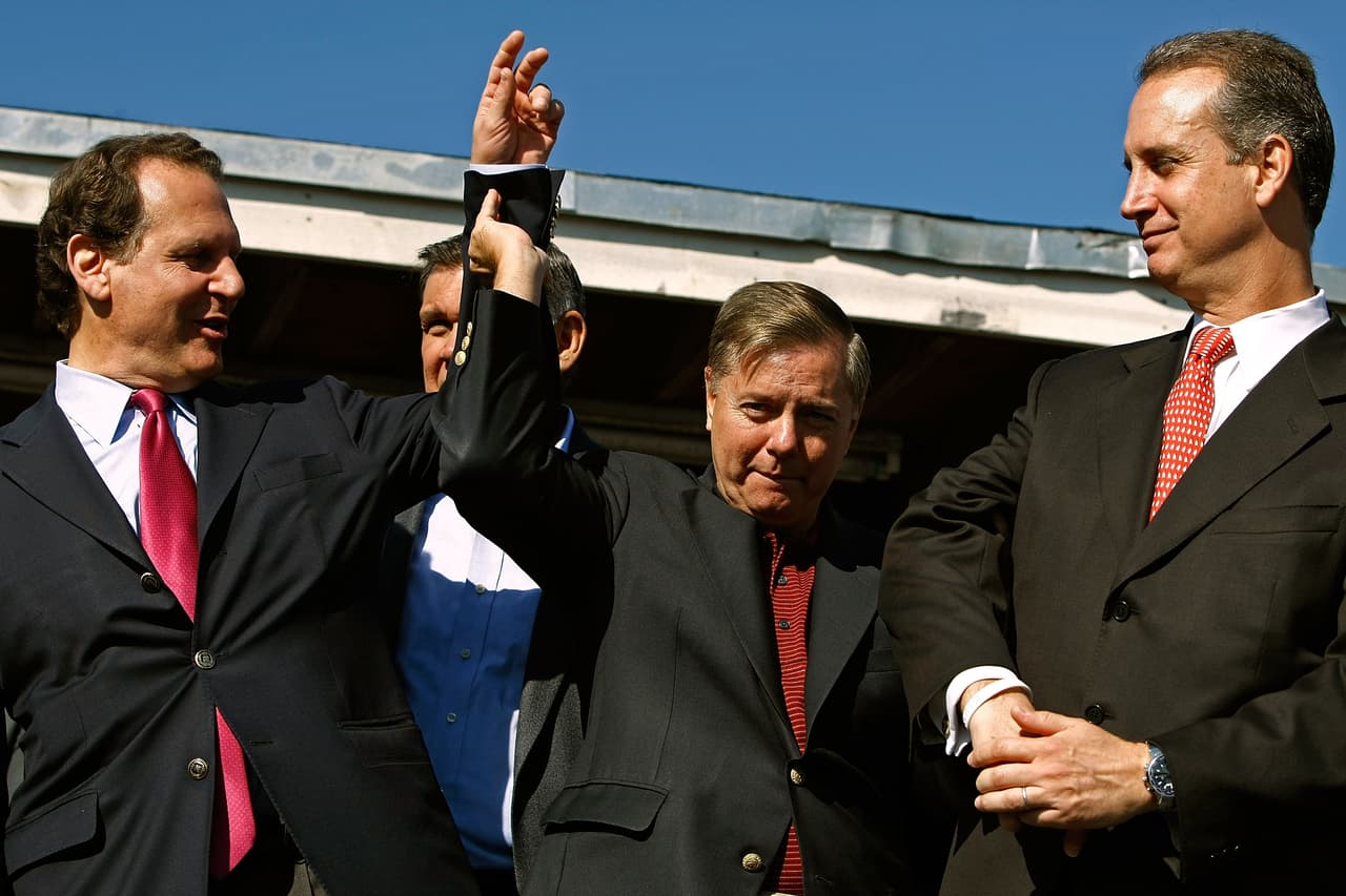 El representante Lincoln Díaz-Balart levanta el brazo del senador Lindsey Graham durante un evento del candidato republicano John McCain en Miami en octubre de 2008.