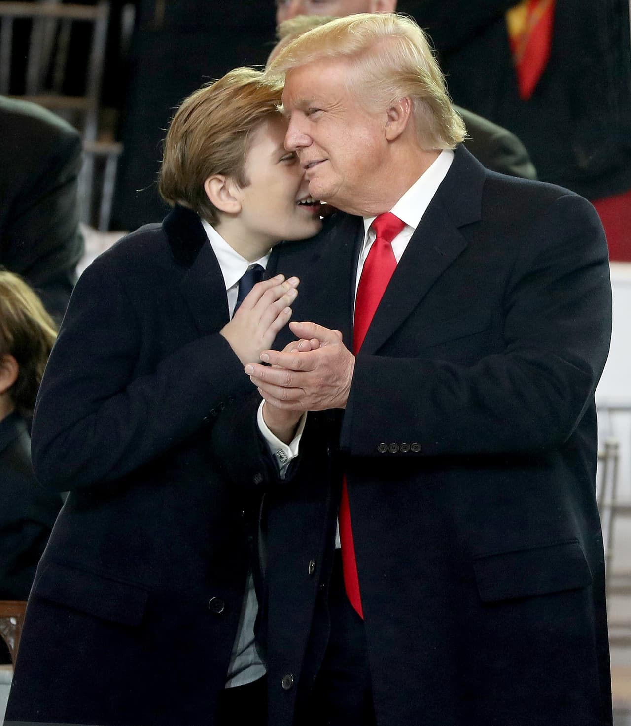 WASHINGTON, DC - JANUARY 20: U.S. President Donald Trump (R) and Barron Trump embrace as they watch the Inaugural Parade from the main reviewing stand in front of the White House on January 20, 2017 in Washington, DC. Donald J. Trump was sworn in today as the 45th president of the United States. (Photo by Patrick Smith/Getty Images)