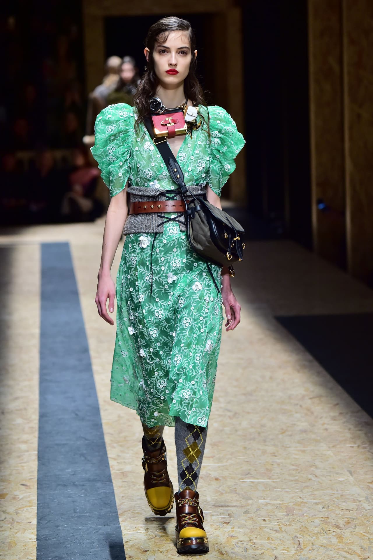 ¿Pero esto...combina? quizás esta pregunta ronda en sus cabezas, y la verdad es que la respuesta es sencilla: no, no combina. Pero de eso se trata, de crear un look que no parezcan que obedece a una tendencia, sino que se presenta como una verdadera expresión creativa de los que somos. Aquí, Prada retoma elementos clásicos y románticos como el vestido de manga de boleros y los combina con unas medias de rombos y unos ugly shoes.