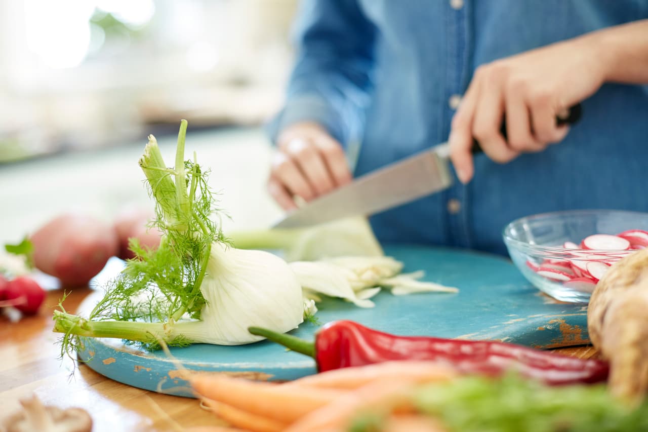 Primero debes cortar un hinojo. Para eso, quita la base del bulbo y sus capas exteriores más oscuras (debería quedar blanco), así como los tallos. Corta el bulbo por la mitad a lo largo y quita el centro. Con un pelador o mandolina obtén rebanadas, o láminas bien finas.