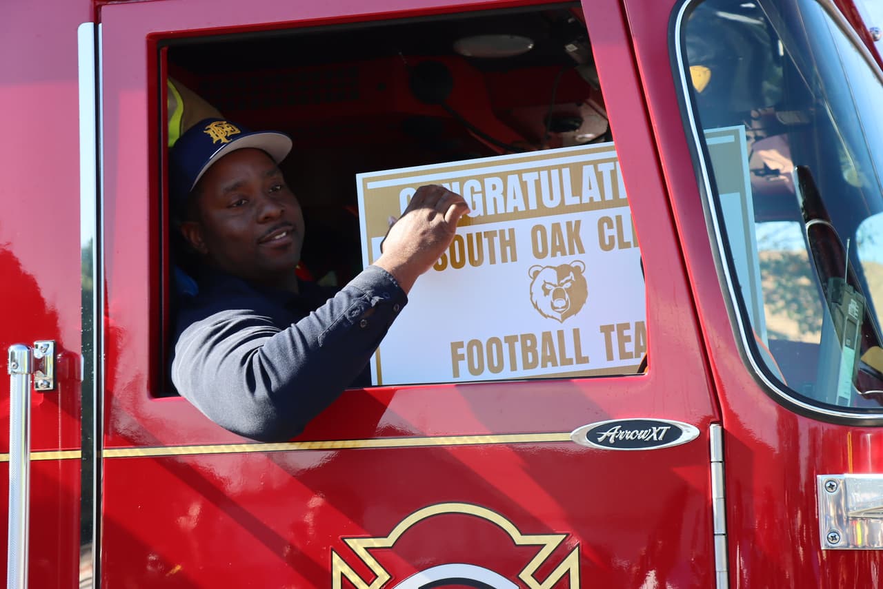 Hasta los bomberos se unieron al desfile llevando a algunos de los jugadores e integrantes del equipo de la preparatoria de South Oak Cliff en el camión de emergencias.