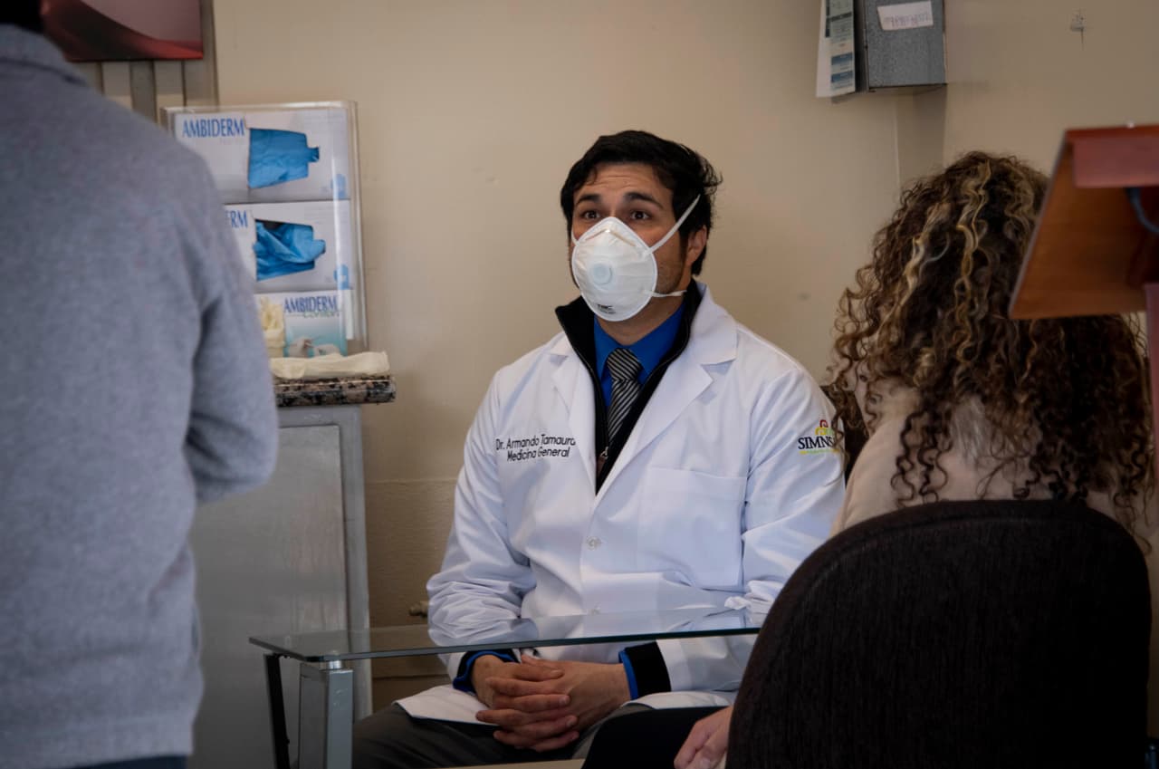 Un médico recibe pacientes en la clínica de prevención y detección instalada en la garita de San Ysidro en Tijuana, Baja California, México, el 20 de Marzo, 2020.