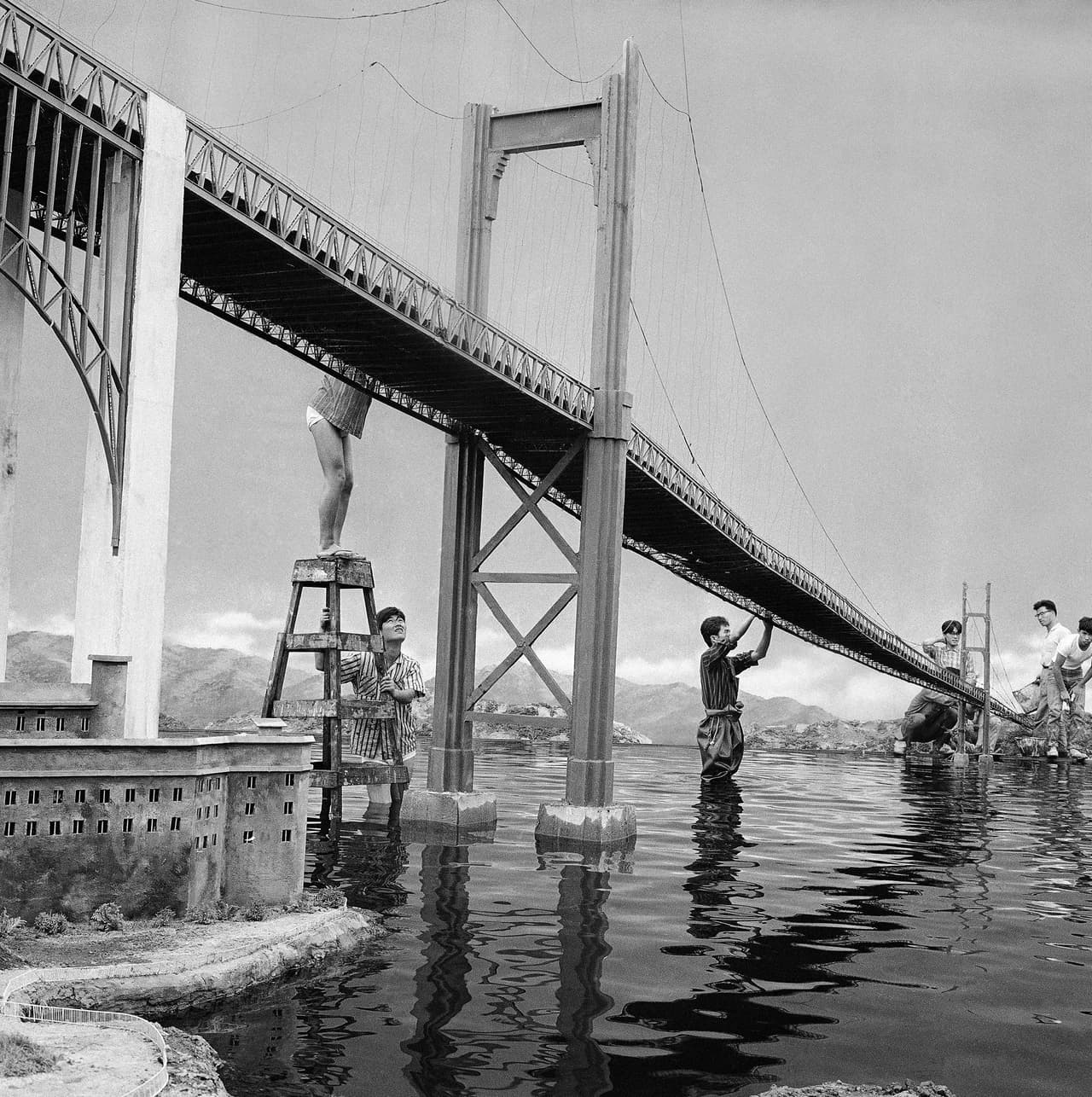 <b>Cinematografía.</b> Desde sus inicios, el puente inspiró a cineastas y artistas por igual. La destrucción del Golden Gate que se observa en varias películas no es exclusiva de los filmes contemporáneos. En esta fotografía de 1906, un grupo de trabajadores construye una réplica a escala para la película japonesa '41 days of terror' en la que la estructura explota.