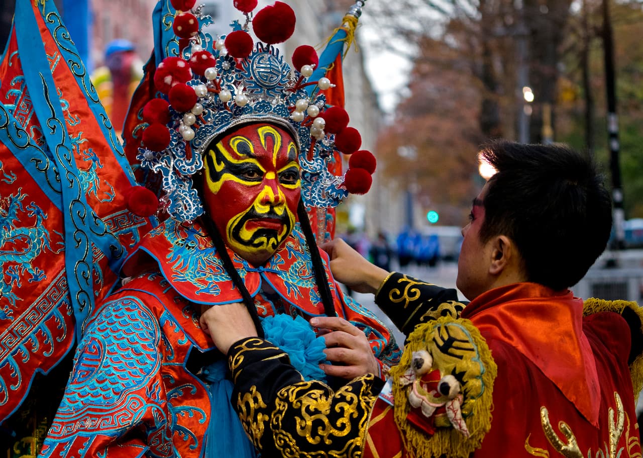 Un personaje con un vestuario tradicional chino se prepara para desfilar en la parada del Día de Acción Gracias. 
<br>