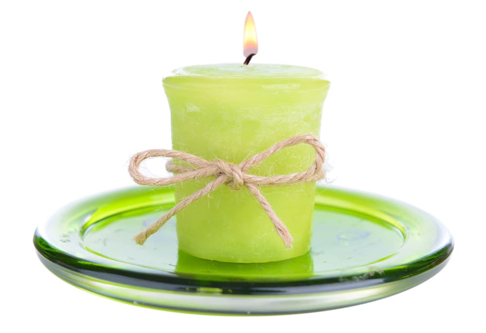 Necesitas una vela verde, que simboliza la prosperidad. La pondrás sobre un platito, de preferencia verde o blanco, y colocarás debajo de ella entre el plato el papel con tu objetivo.