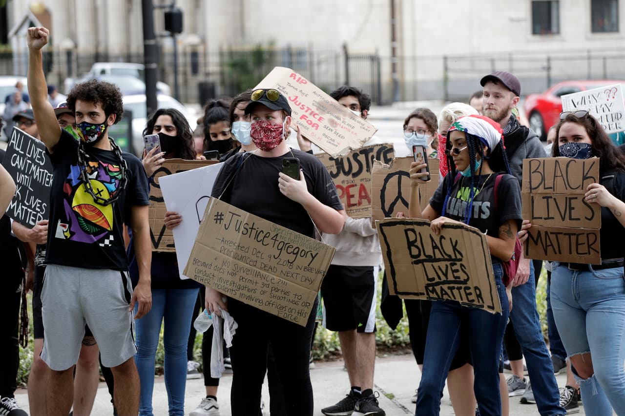 Un grupo reducido de personas coreó consignas y mostró carteles en el Lake Eola Park después de venir marchando desde el City Hall, en Orlando, Florida.
