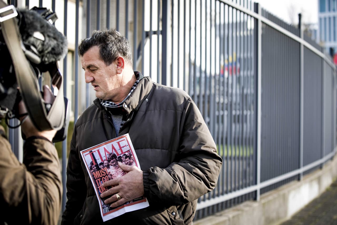 Fikret Alic, un sobreviviente de la guerra y víctima de Ratko Mladic, sostiene la portada de la publicación semanal 'Time' de 1992, donde él mismo aparece en un campo de concentración en Bosnia. Esperaba el veredicto que finalmente condenó al ex comandante en La Haya.