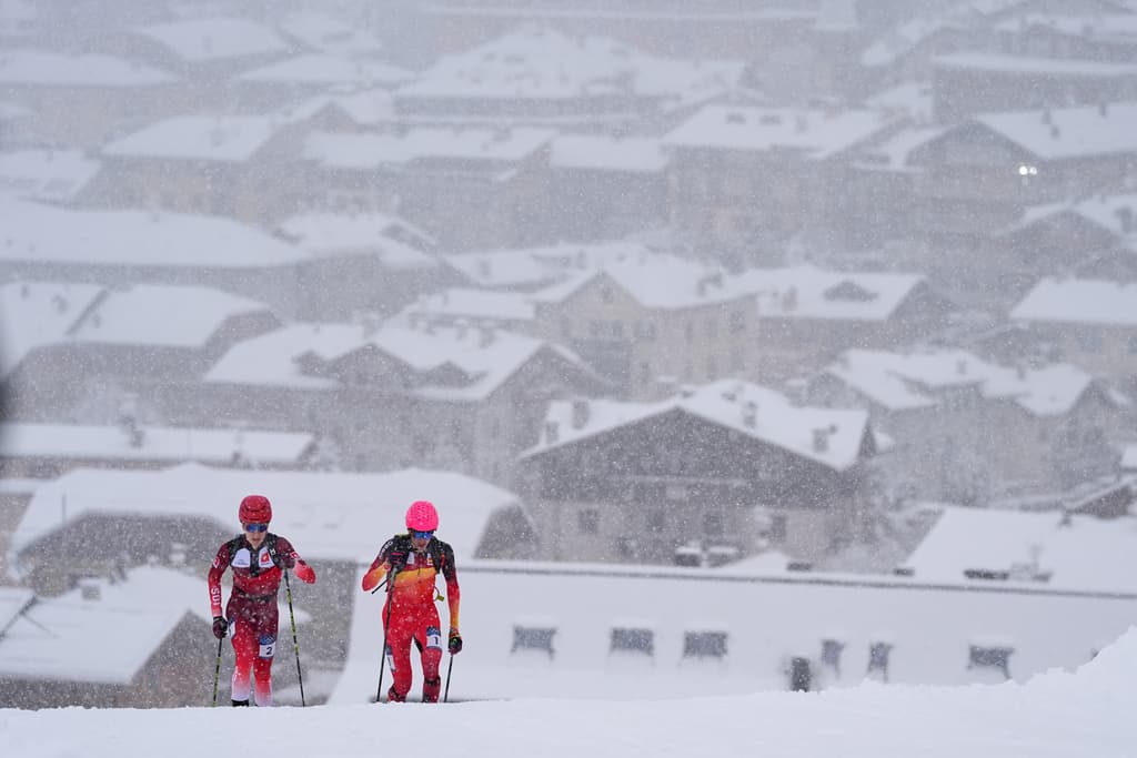 El español Oriol Cardona Coll, a la derecha, compite junto al suizo Jon Kistler con el pueblo nevado de Bormio como telón de fondo, durante la semifinal masculina de esqui de montaña sprint, en los Juegos Olímpicos de Invierno de 2026, en Bormio, Italia, el jueves 19 de febrero de 2026.