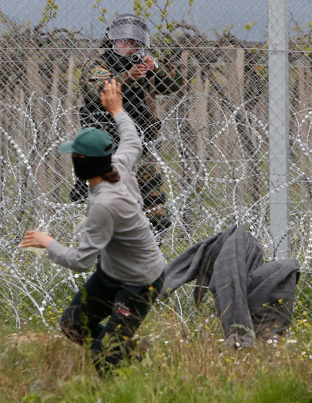 Un agente que trataba de quitar el alambre del muro fronterizo huye cuando un agente.