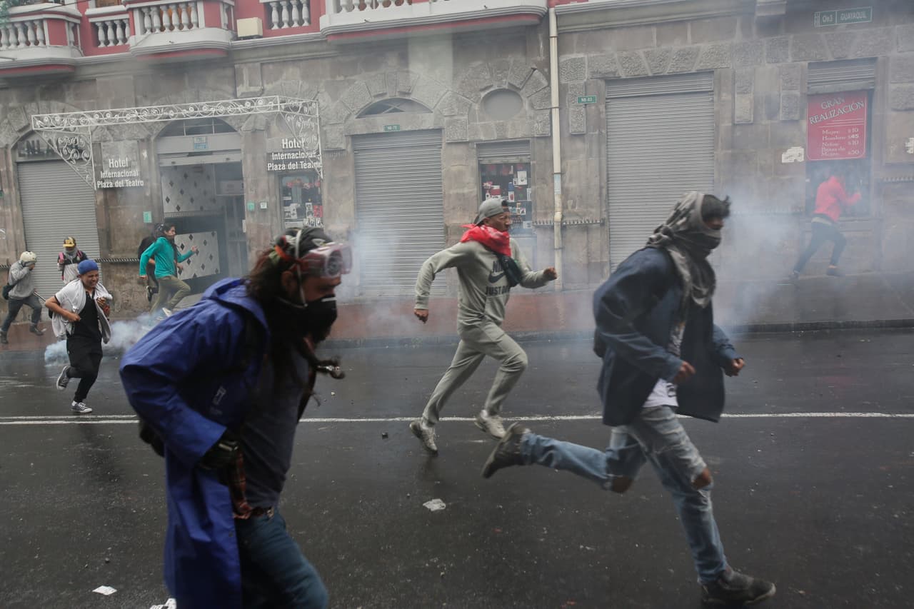 Manifestantes huyen tras ser dispersados por la policía durante una protesta contra la eliminación de los subsidios al combustible anunciada por el presidente Lenín Moreno, en Quito, Ecuador, el jueves 3 de octubre de 2019. (AP Foto / Dolores Ochoa)