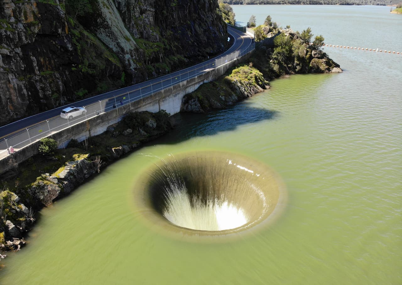 En esta foto tomada el 11 de marzo de 2019, el agua fluye hacia el icónico aliviadero Glory Hole en la presa Monticello en el lago Berryessa, California. (Foto AP/Terry Chea)