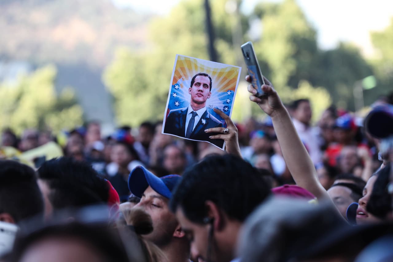 ST01. SANTIAGO (CHILE), 23/01/2019.- Una persona sostiene una fotografía del autoproclamado presidente de Venezuela, Juan Guaidó, durante una concentración de miles de venezolanos radicados en Chile este miércoles en la Plaza Italia de Santiago (Chile) para mostrar su apoyo a Guaidó, líder de la Asamblea Nacional de Venezuela, y cuya decisión de autoproclamación fue reconocida por la mayoría de los países de la región, además de Estados Unidos y Canadá. EFE/Alberto Valdés