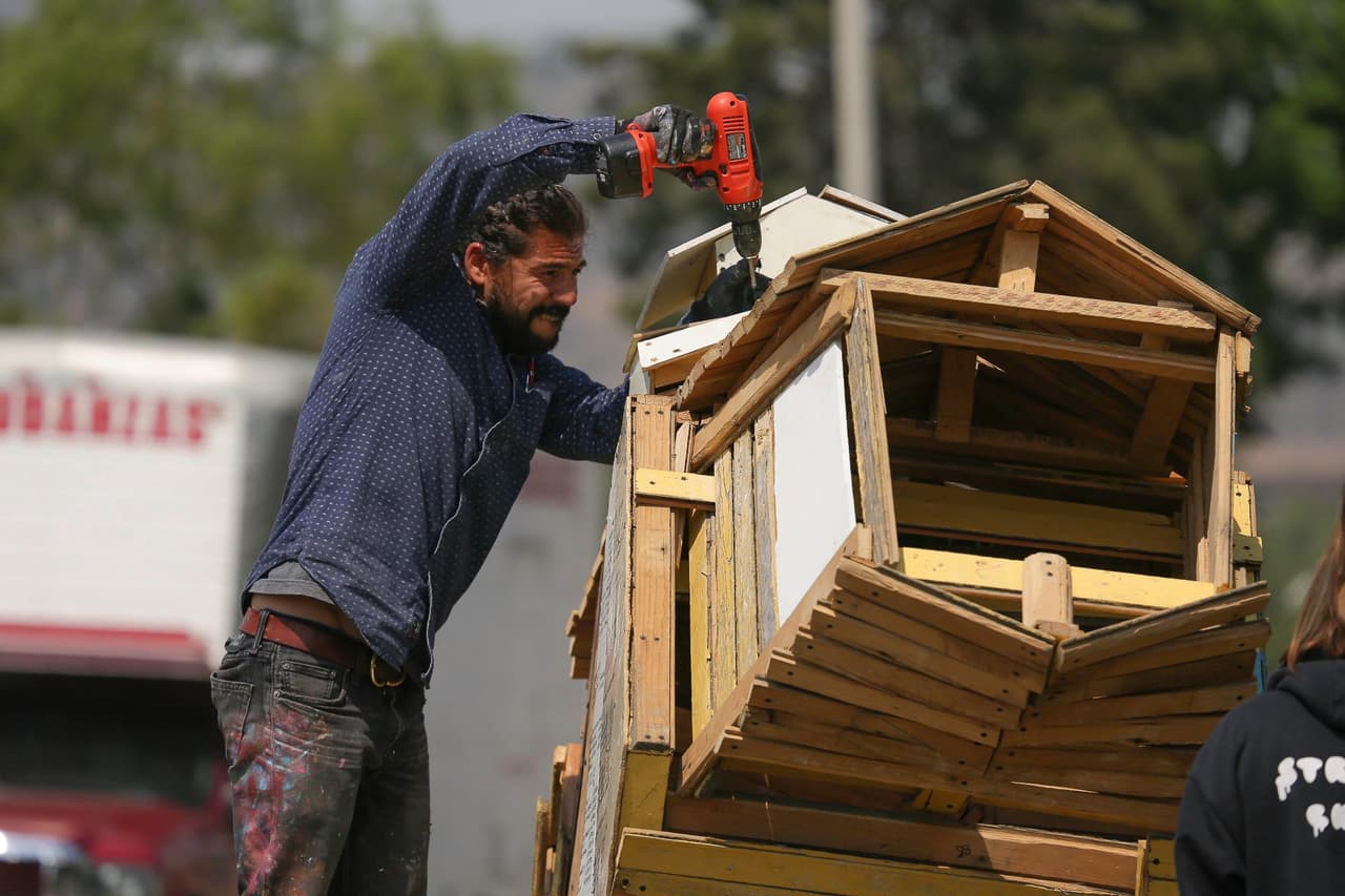 El Transportapueblos está fijado al suelo y en él están escritos varios mensajes de apoyo para quienes se dirigen a EEUU. "Es una forma de decirle a los hermanos migrantes, sobre todo a los latinoamericanos, que quizá no nos conocemos, pero me importas", dice el artista Alfredo Gutiérrez.