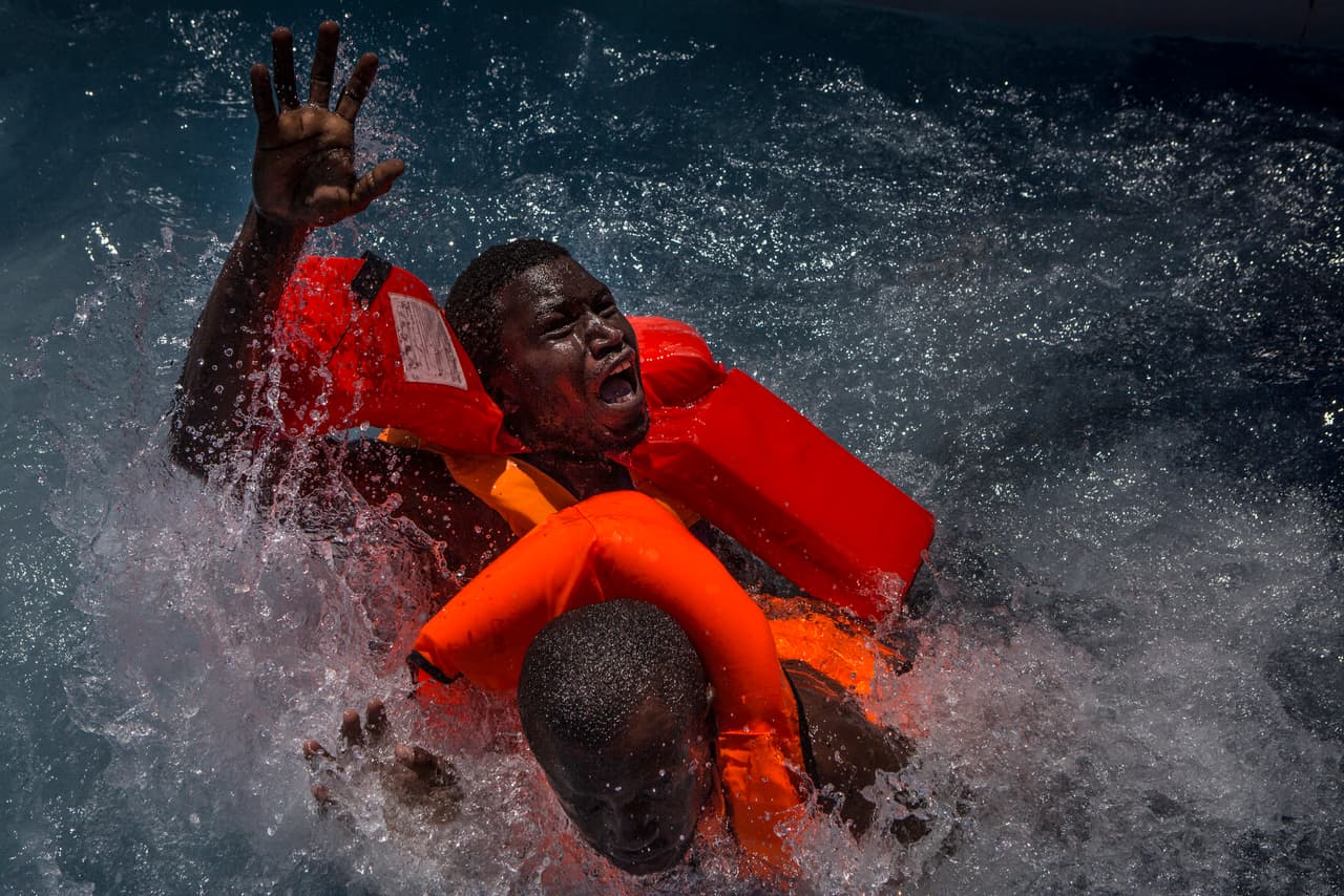 <b>Migración en el Mediterráneo</b>. El fotógrafo Mathieu Willcocks retrató a los migrantes que luchan por atravesar el mediterráneo para llegar a Europa. Con su serie de fotografías obtuvo el tercer premio en la categoría Noticias del concurso World Press Photo. En esta imagen, dos hombres luchan en el agua cuando su bote de goma se desinfló en el mar.