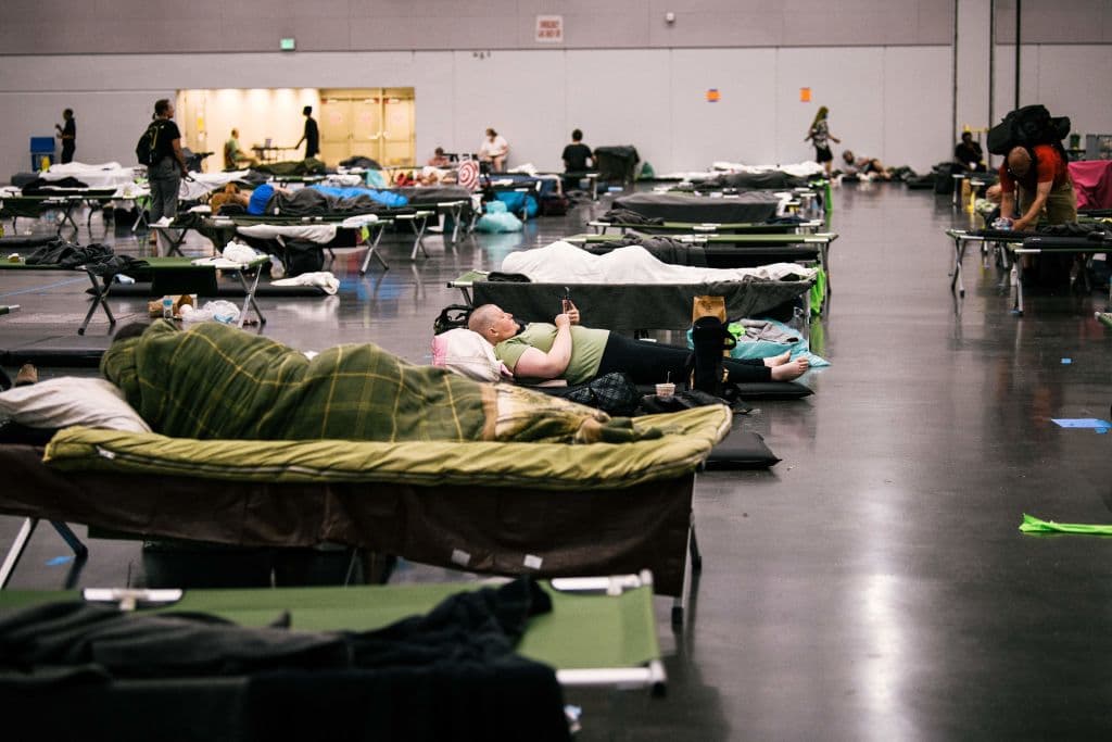 En esta foto se ve a varias personas descansando en una estación de enfriamiento en el Oregon Convention Center, en Portland, estado de Oregon. Los médicos temen que las altas temperaturas de este fin de semana puedan desatar muertes y graves problemas de salud, que ya además de las muy altas temperaturas durante el día también las noches serán muy cálidas, por lo que el cuerpo no tiene mucho tiempo para reponerse del calor.
