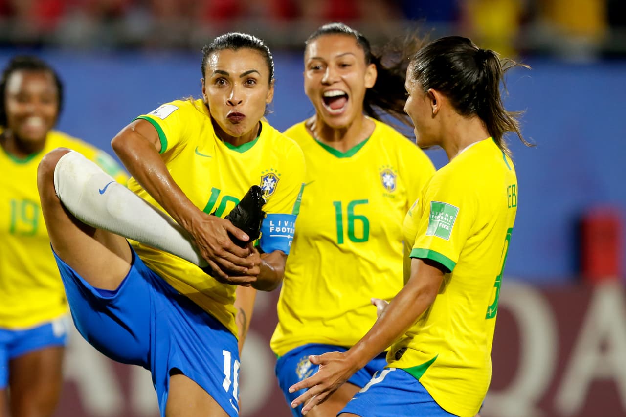 Marta a punto de besar los zapatos de fútbol con el logo de 'Go Equal'.