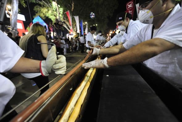 Un hotdog de 656.167 pies (200 metros) de largo se cocinó en una parrilla especialmente construida en un intento de batir un récord Guinness en la Feria Internacional de Mariano Roque Alonso, Paraguay, el 15 de julio de 2011.