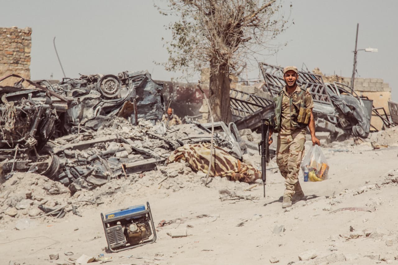 "Nos cruzamos con soldado de las fuerza iraquíes, estaba alegre de que lo fotografiaran con su bolsa de comida. Caminaba junto a una planta de energia portatil de miles que hay en Mosul por todas partes. La ciudad no tiene servicio de energía eléctrica".